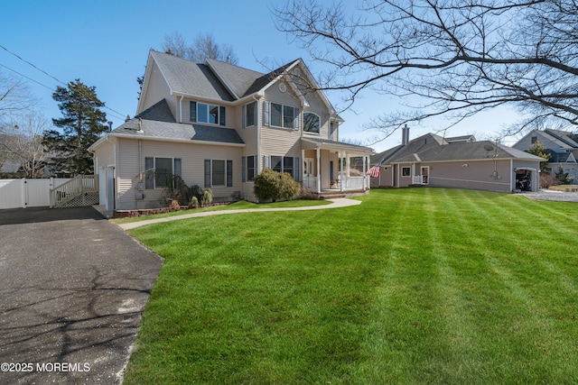 view of front of house featuring a shingled roof, a front lawn, fence, a porch, and a gate