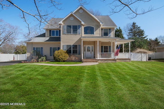 view of front of house with a porch, fence, and a front yard