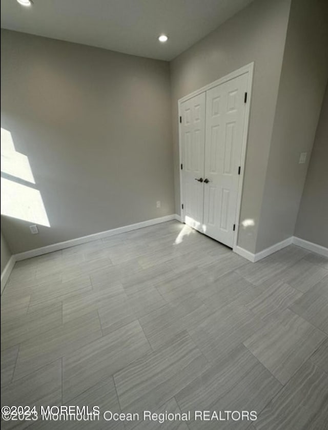 unfurnished bedroom featuring recessed lighting, a closet, and baseboards