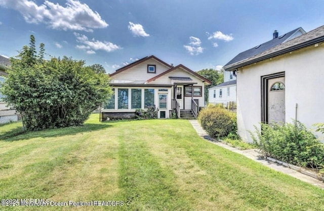 back of house featuring a yard and fence