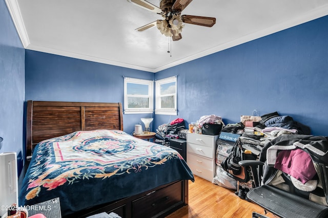 bedroom with crown molding, a ceiling fan, and wood finished floors