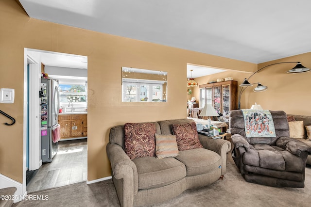 carpeted living room with a sink