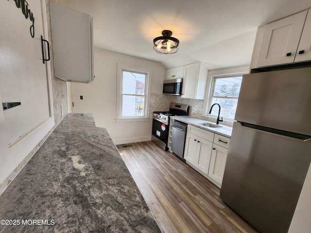 kitchen featuring a sink, tasteful backsplash, appliances with stainless steel finishes, and a healthy amount of sunlight