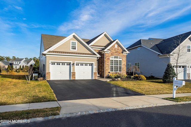 view of front facade featuring a front yard, stone siding, and driveway