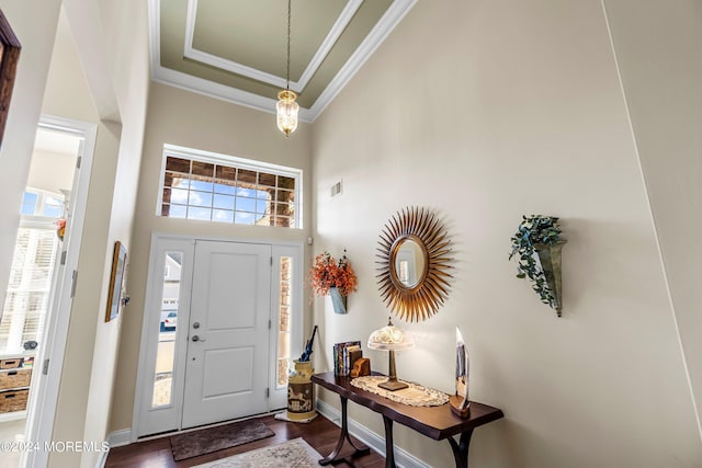 entrance foyer featuring visible vents, plenty of natural light, a high ceiling, and ornamental molding