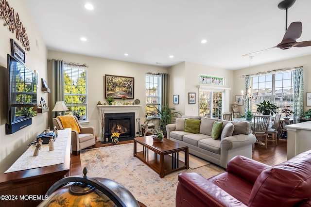 living area with recessed lighting, plenty of natural light, wood finished floors, and a fireplace with flush hearth