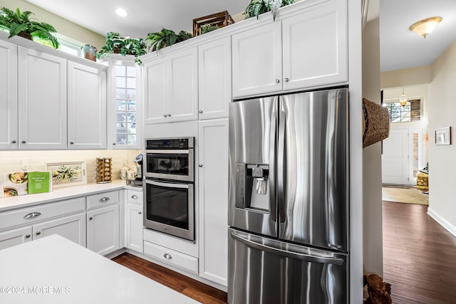 kitchen featuring light countertops, decorative backsplash, dark wood-style floors, white cabinets, and stainless steel appliances