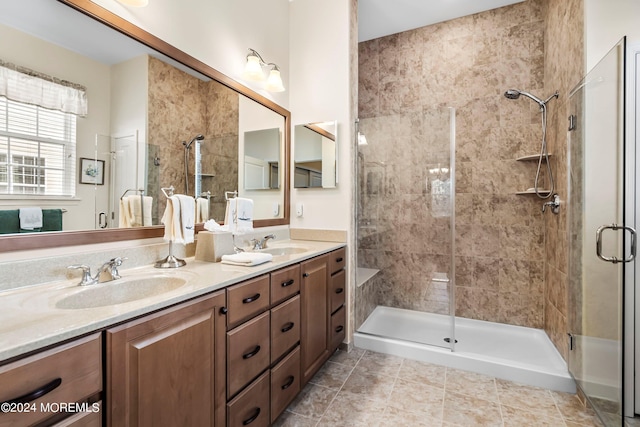 full bath with tile patterned floors, a shower stall, double vanity, and a sink