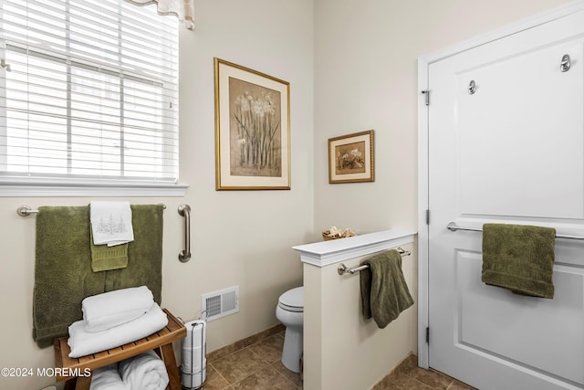 bathroom featuring tile patterned floors, visible vents, toilet, and baseboards