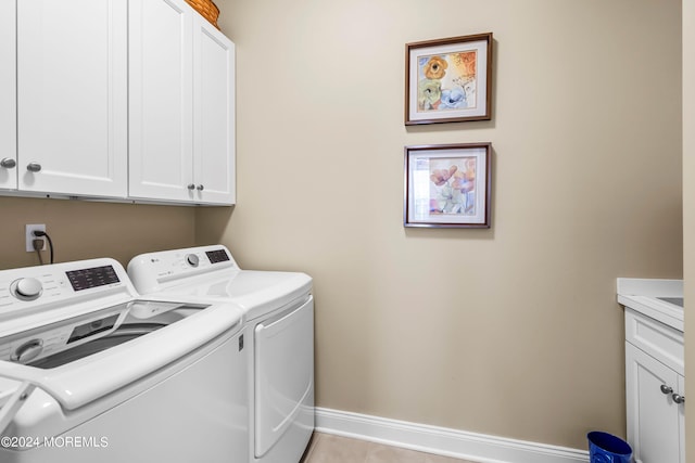 laundry area with cabinet space, baseboards, and washer and clothes dryer