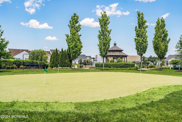 surrounding community with a gazebo, fence, and a lawn