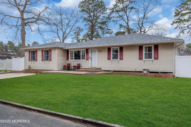 single story home featuring entry steps, a front lawn, fence, and a shingled roof