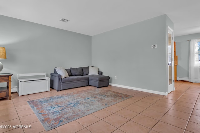 living area with tile patterned flooring, visible vents, and baseboards