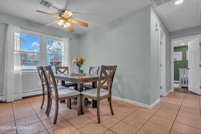 dining room with visible vents, a ceiling fan, light tile patterned floors, baseboards, and attic access