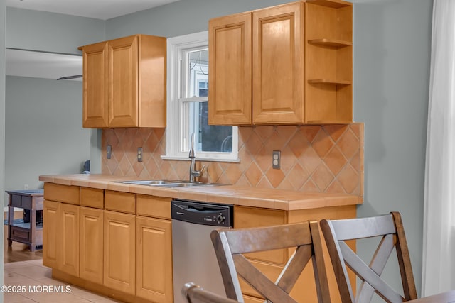 kitchen with a sink, tasteful backsplash, stainless steel dishwasher, tile countertops, and light tile patterned floors