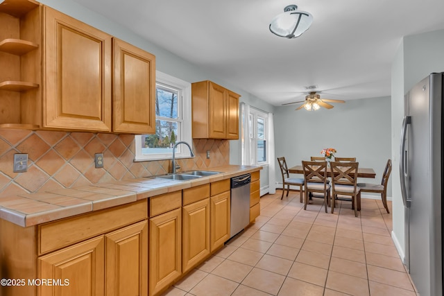 kitchen with a sink, tile countertops, decorative backsplash, appliances with stainless steel finishes, and open shelves