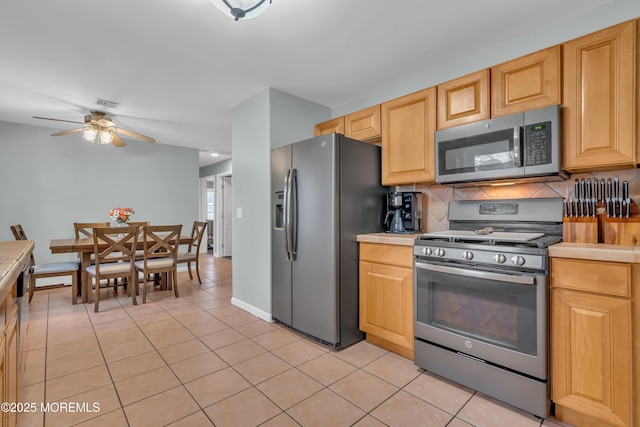 kitchen featuring decorative backsplash, light countertops, a ceiling fan, and stainless steel appliances