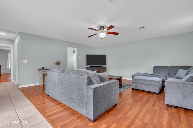 living area with light wood finished floors, visible vents, baseboards, and ceiling fan