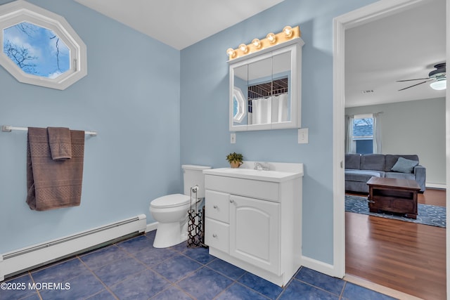 full bath with tile patterned floors, toilet, a baseboard heating unit, ceiling fan, and vanity