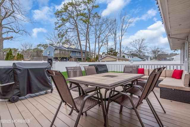 deck featuring outdoor dining area and a fenced backyard