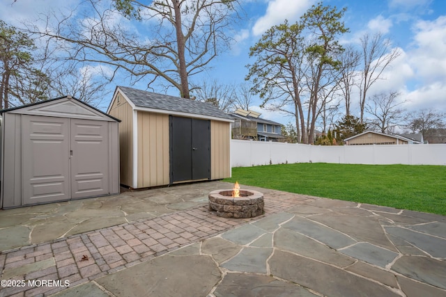 view of patio featuring fence, a storage shed, an outdoor structure, and an outdoor fire pit