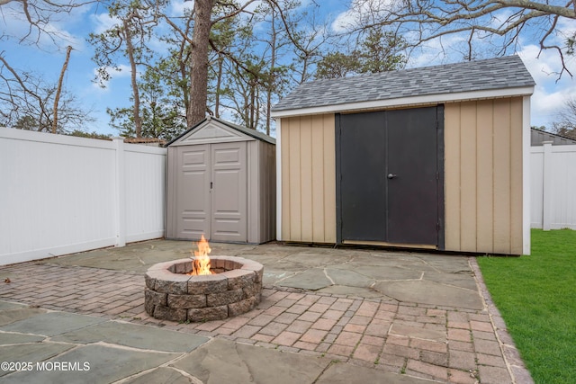 view of shed with an outdoor fire pit and a fenced backyard