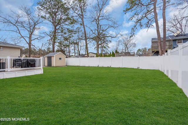 view of yard with an outdoor structure, a fenced backyard, and a shed