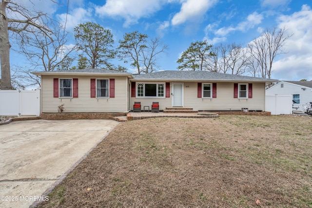 ranch-style home with a gate, a front yard, and fence