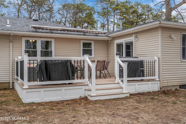 rear view of house featuring a wooden deck and a shingled roof