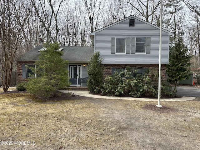 view of front of home featuring brick siding and a chimney