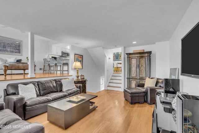 living room with stairway, recessed lighting, and light wood finished floors