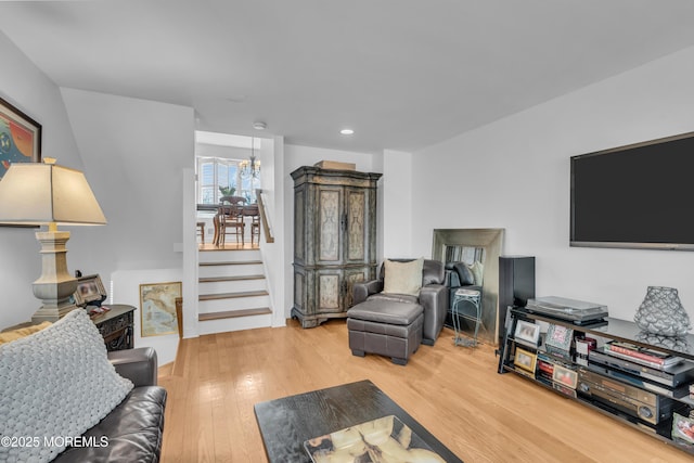 living room with a notable chandelier, recessed lighting, stairs, and wood finished floors