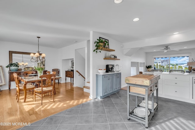 dining area featuring light tile patterned floors, recessed lighting, and ceiling fan with notable chandelier