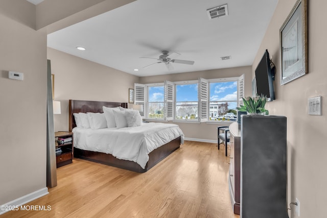 bedroom featuring visible vents, baseboards, a ceiling fan, and light wood finished floors