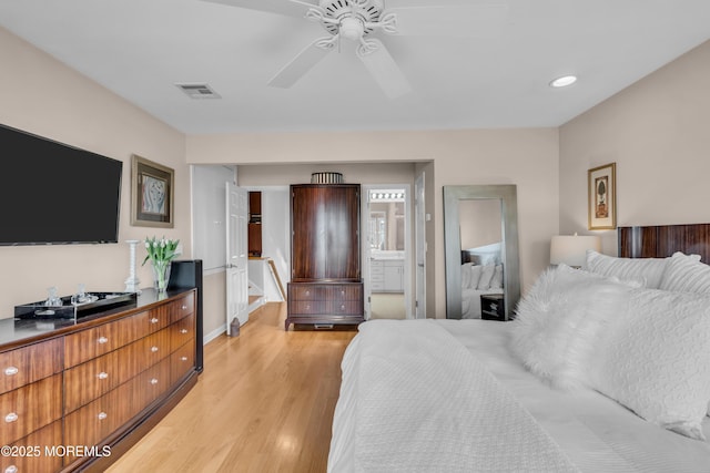 bedroom with ceiling fan, ensuite bath, visible vents, and light wood-type flooring