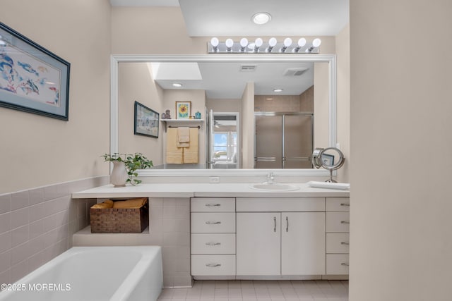 bathroom with visible vents, a garden tub, a stall shower, and vanity