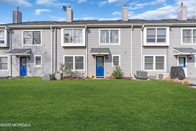 exterior space featuring a front yard, cooling unit, and a chimney