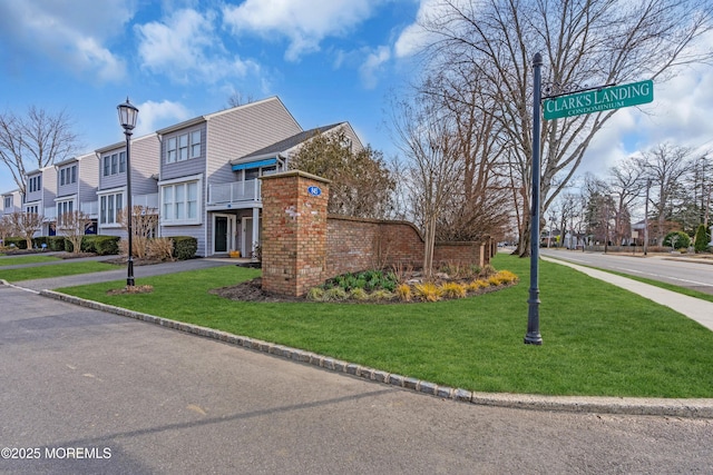 exterior space featuring a residential view, a lawn, and driveway