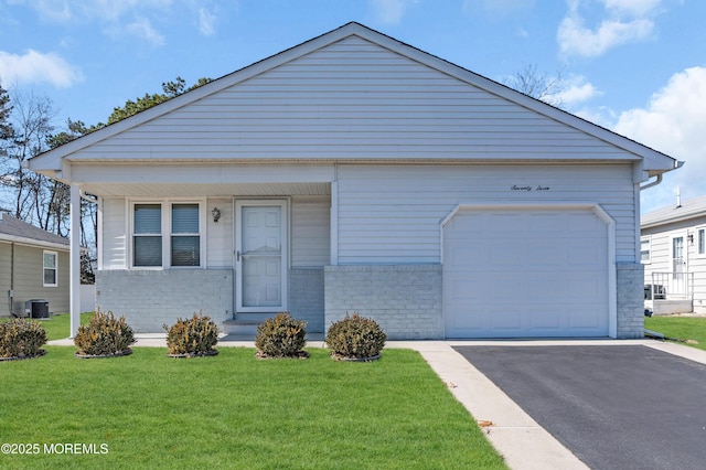 view of front of home with central air condition unit, driveway, a front yard, a garage, and brick siding