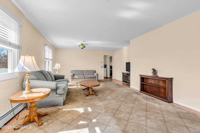 living area featuring visible vents, a baseboard heating unit, and baseboards