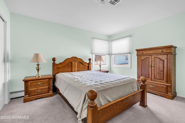 bedroom with a baseboard heating unit, visible vents, and light carpet