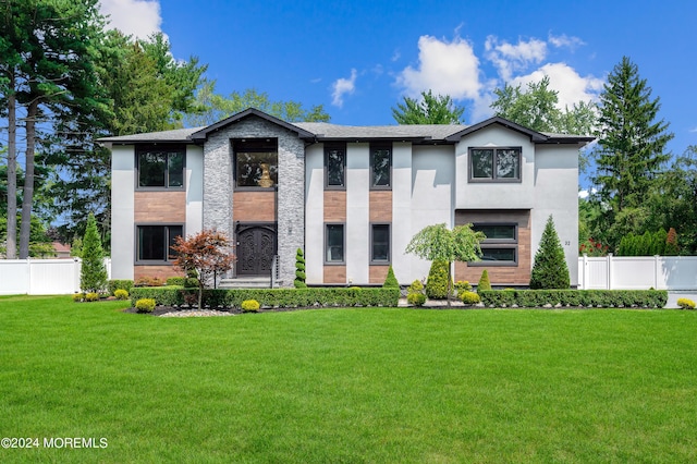 view of front of house featuring a front lawn, fence, and stucco siding