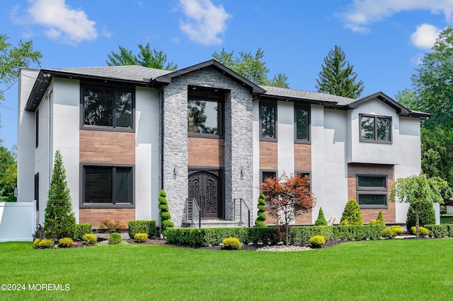 view of front of home with a front yard, fence, roof with shingles, and stucco siding