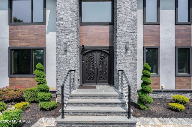 view of exterior entry featuring french doors and stucco siding