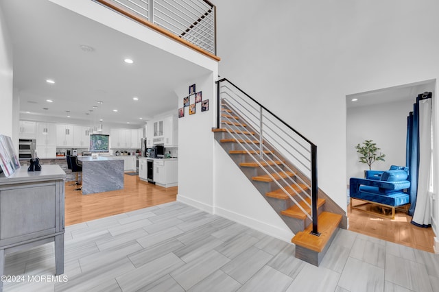 stairs with recessed lighting, baseboards, and wood finish floors