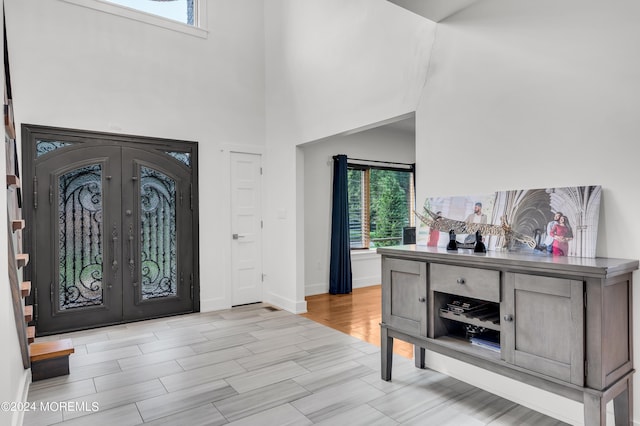 entryway featuring french doors, plenty of natural light, light wood-style floors, and baseboards