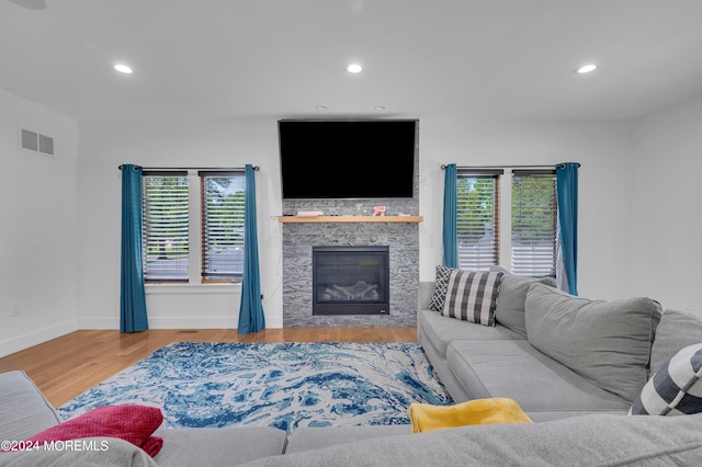 living area featuring visible vents, wood finished floors, recessed lighting, a fireplace, and baseboards