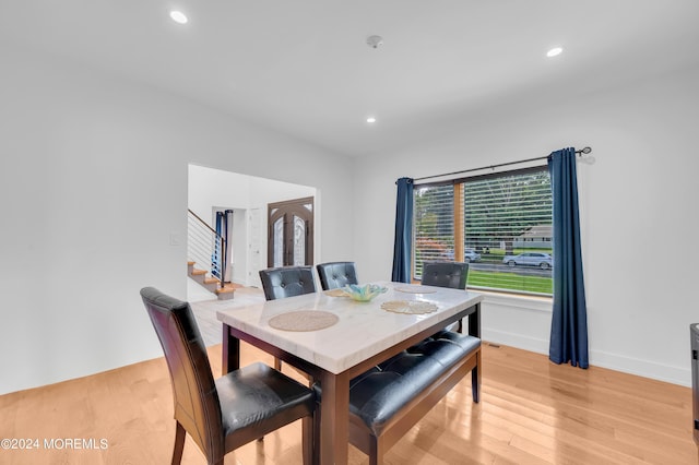 dining room with recessed lighting, light wood-style floors, and stairs