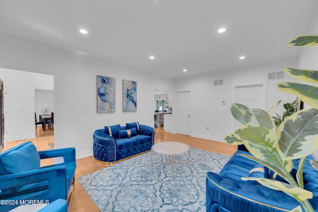 living area with visible vents, recessed lighting, and wood finished floors