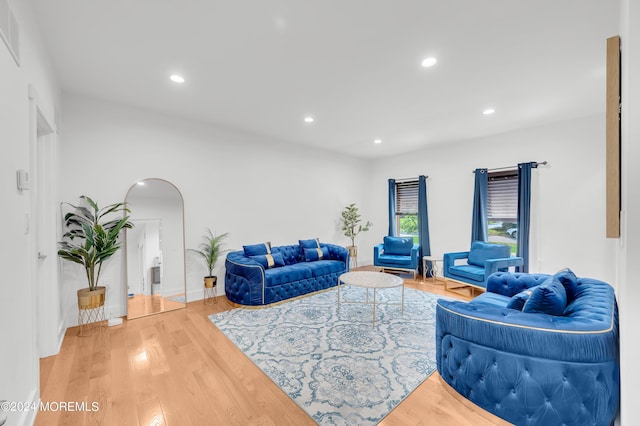 living room with arched walkways, recessed lighting, baseboards, and wood finished floors